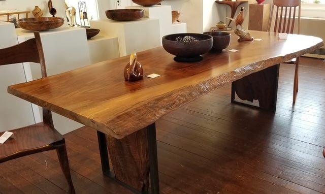 This fabulous natural edge dining table is made of fiddleback Bastogne walnut from Sonoma, CA.  It has a wonderful grain pattern that runs the length of the table in warm honey and reddish tones.  It has a natural edge on one side and the base is created from pieces of the same slab as the top of the table.  The base is made of the walnut and metal with a gun blue patina.  